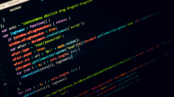 A imagem mostra uma tela preta de um dispositivo tecnológico, que exibe um conjunto de códigos coloridos de script em linguagem computacional