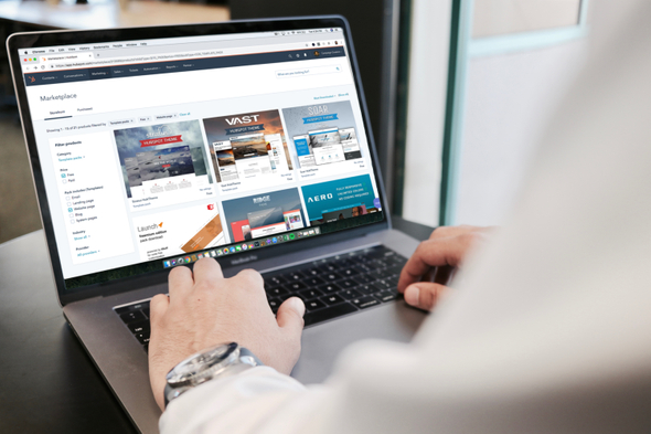 A imagem mostra um homem usando um notebook. Na tela do computador, é possível ver a interface de algum site de vendas pela internet, que ainda traz no cabeçalho da página os dizeres “marketplace”.