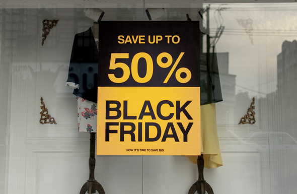  A imagem mostra uma vitrine de loja de roupa com um cartaz da Black Friday que anuncia até 50% de desconto.